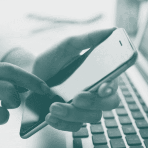 Mobile phone held over laptop