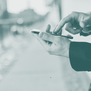 Cropped hands holding smartphone outside business office