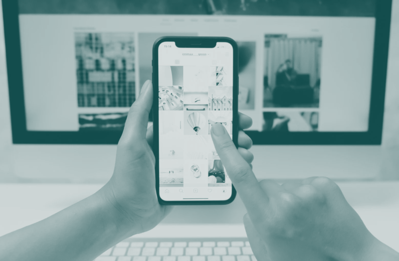 Person holding smartphone displaying advertising